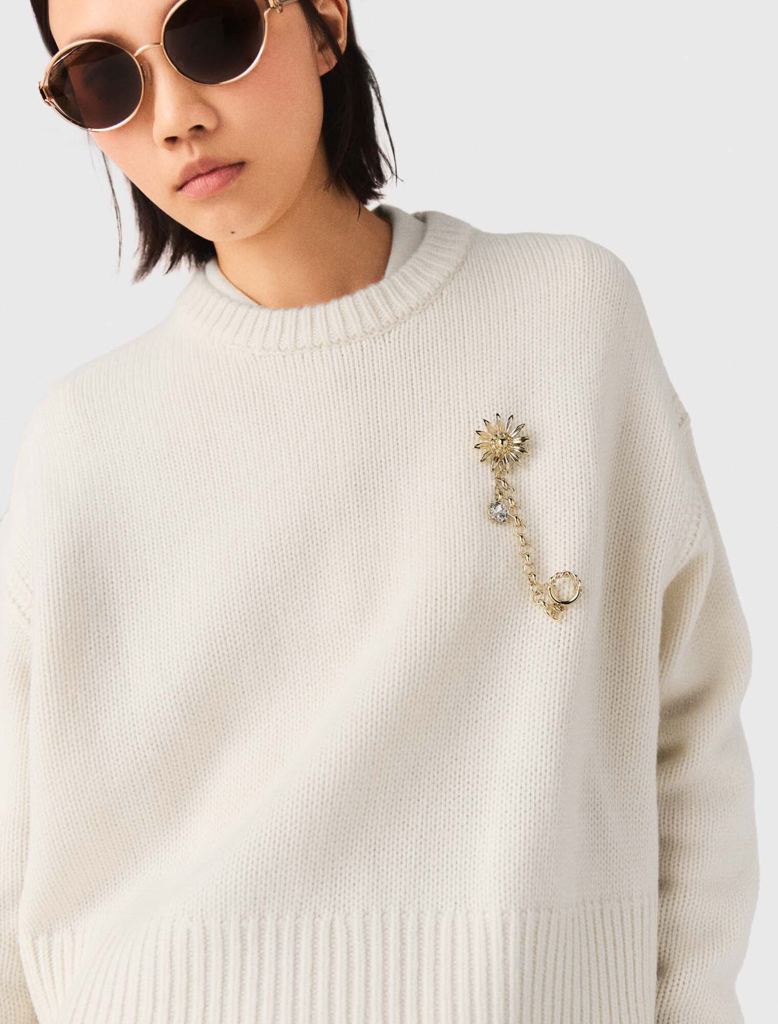 Jumper with floral brooch